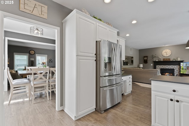 8775 SW Comanche Way, Tualatin, OR 97062 - kitchen with stainless steel fridge with ice dispenser, light wood-type flooring, white cabinets, open floor plan, and recessed lighting