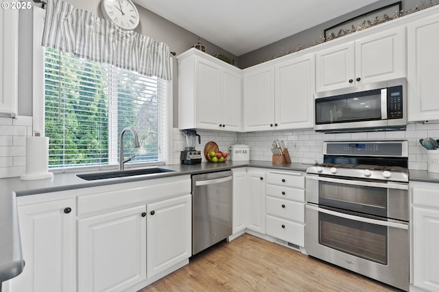 8775 SW Comanche Way, Tualatin, OR 97062 - kitchen with stainless steel appliances, healthy amount of natural light, white cabinetry, and backsplash