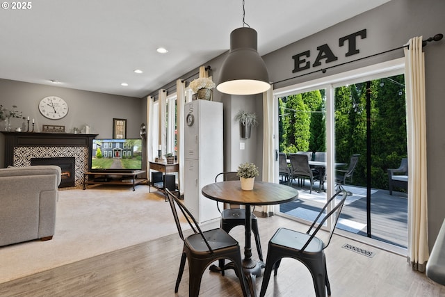 8775 SW Comanche Way, Tualatin, OR 97062 - dining area featuring recessed lighting, a tiled fireplace, and light wood-style flooring