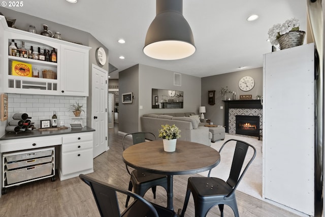 8775 SW Comanche Way, Tualatin, OR 97062 - dining space featuring light wood-type flooring, recessed lighting, and a tiled fireplace