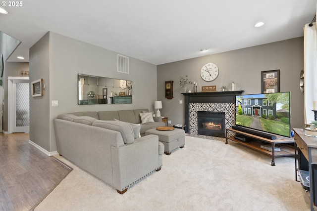 8775 SW Comanche Way, Tualatin, OR 97062 - carpeted living room featuring a tiled fireplace, recessed lighting, and wood finished floors