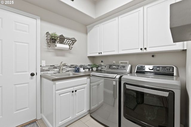 8775 SW Comanche Way, Tualatin, OR 97062 - washroom featuring washing machine and dryer, cabinet space, and light tile patterned flooring