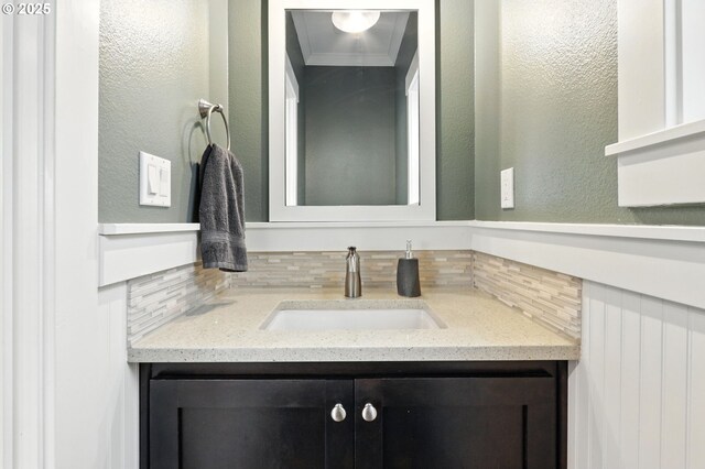 18 NE Cook St, Portland, OR 97212 - bathroom featuring vanity, tasteful backsplash, a textured wall, and ornamental molding