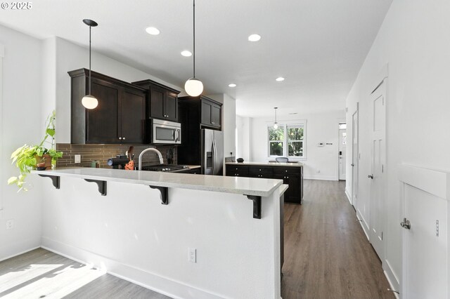 18 NE Cook St, Portland, OR 97212 - kitchen with stainless steel appliances, dark wood finished floors, light countertops, recessed lighting, and a peninsula