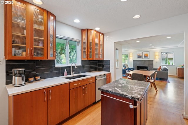 9004 SW 36th Ave, Portland, OR 97219 - kitchen with a sink, dishwasher, decorative backsplash, a center island, and light wood-style flooring