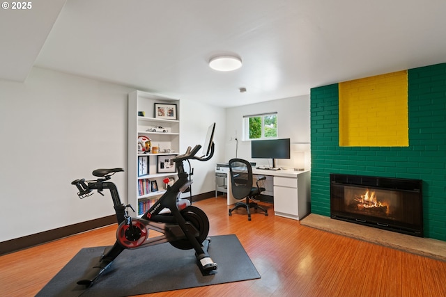 9004 SW 36th Ave, Portland, OR 97219 - exercise area with light wood-type flooring, a brick fireplace, and baseboards