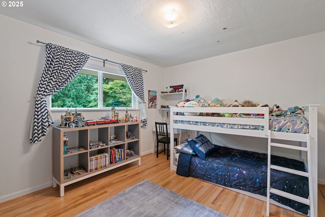 9004 SW 36th Ave, Portland, OR 97219 - bedroom featuring wood finished floors, a textured ceiling, and baseboards