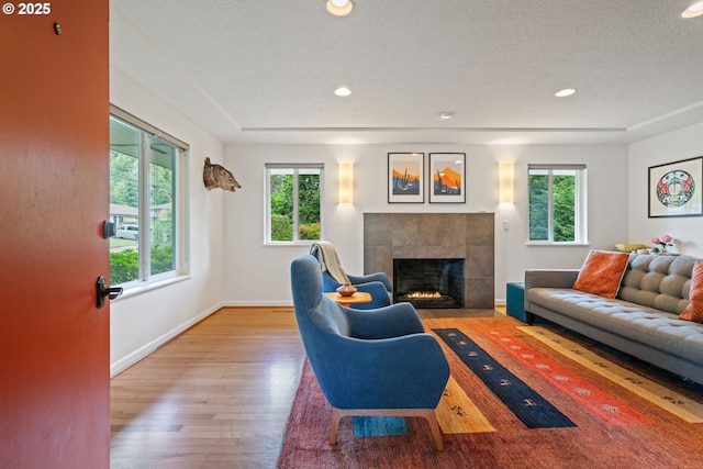 9004 SW 36th Ave, Portland, OR 97219 - living area featuring a tiled fireplace, wood finished floors, baseboards, a textured ceiling, and recessed lighting