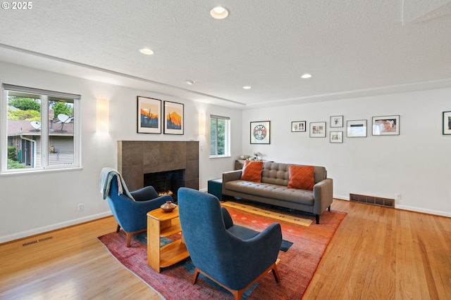 9004 SW 36th Ave, Portland, OR 97219 - living area with a tile fireplace, healthy amount of natural light, wood finished floors, baseboards, and recessed lighting