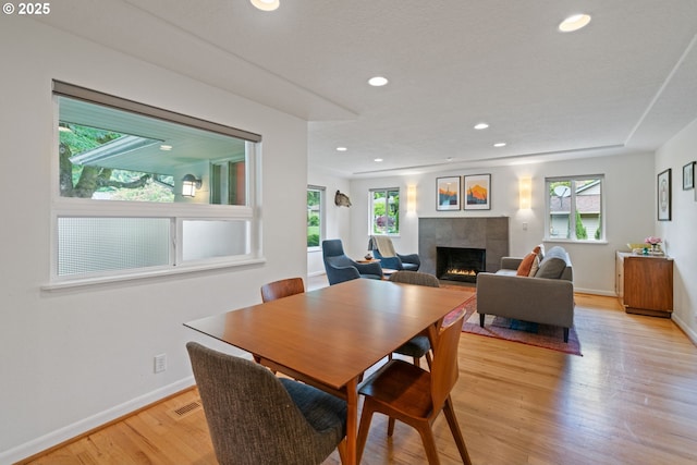 9004 SW 36th Ave, Portland, OR 97219 - dining area featuring a fireplace, healthy amount of natural light, light wood finished floors, baseboards, and recessed lighting