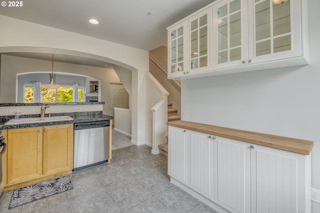 8800 SW 147th Ter Unit 103, Beaverton, OR 97007 - kitchen with stainless steel dishwasher, arched walkways, dark countertops, glass insert cabinets, and hanging light fixtures
