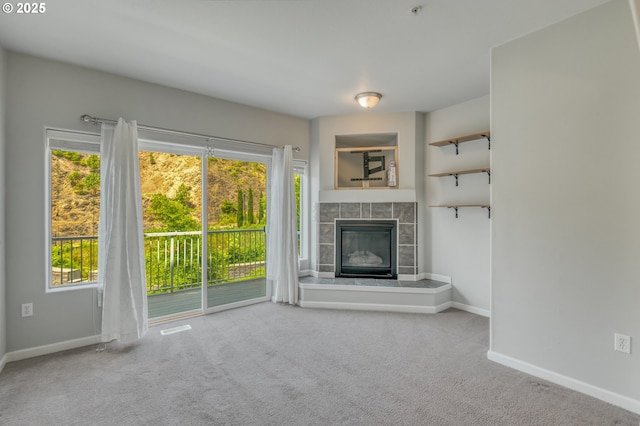 8800 SW 147th Ter Unit 103, Beaverton, OR 97007 - unfurnished living room featuring carpet floors, healthy amount of natural light, and a tiled fireplace