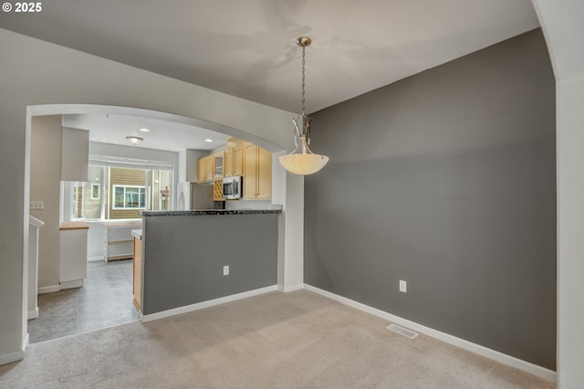 8800 SW 147th Ter Unit 103, Beaverton, OR 97007 - kitchen featuring stainless steel appliances, dark countertops, light carpet, and arched walkways