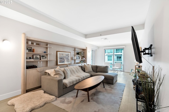 living area with light wood-type flooring and baseboards