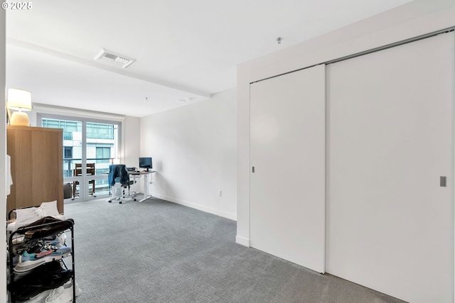 carpeted office space featuring baseboards and visible vents