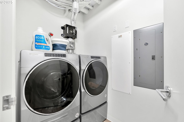 washroom featuring laundry area, washing machine and dryer, and electric panel