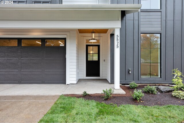 doorway to property with board and batten siding and concrete driveway