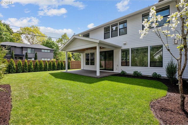 back of property with a patio, fence, and a lawn