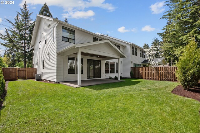 back of property with central air condition unit, a patio area, a fenced backyard, and a lawn