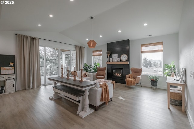 living room with lofted ceiling, plenty of natural light, a fireplace, and visible vents