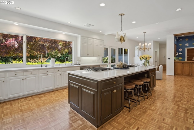 1890 S Greenwood Rd, Portland, OR 97219 - kitchen featuring recessed lighting, white cabinets, light countertops, a kitchen bar, and a chandelier