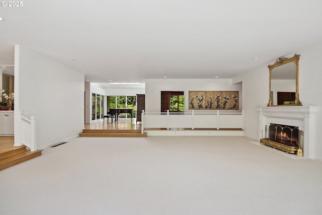1890 S Greenwood Rd, Portland, OR 97219 - unfurnished living room with a warm lit fireplace, recessed lighting, light colored carpet, and baseboards