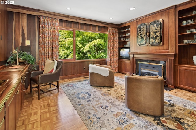 1890 S Greenwood Rd, Portland, OR 97219 - living area featuring a glass covered fireplace, built in features, wood walls, and recessed lighting