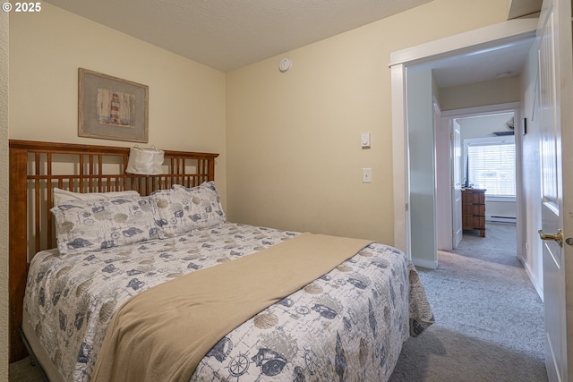 carpeted bedroom with baseboard heating and baseboards