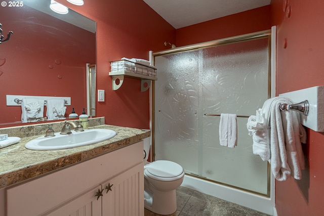 full bathroom featuring toilet, vanity, and a stall shower