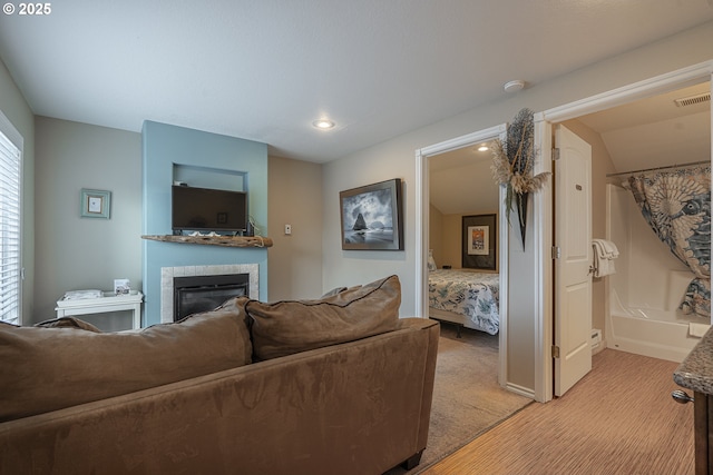 living room with visible vents, light carpet, a glass covered fireplace, and recessed lighting