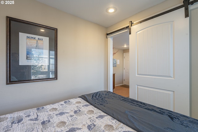 bedroom with a barn door and recessed lighting