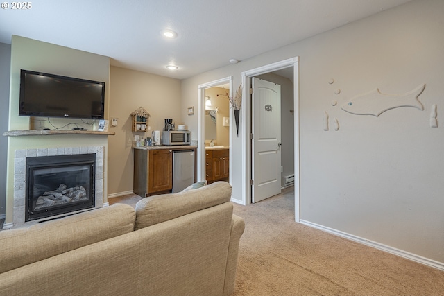 living area featuring recessed lighting, baseboards, a tiled fireplace, and light colored carpet