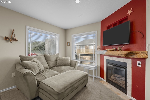 living room with light carpet, a fireplace, and baseboards