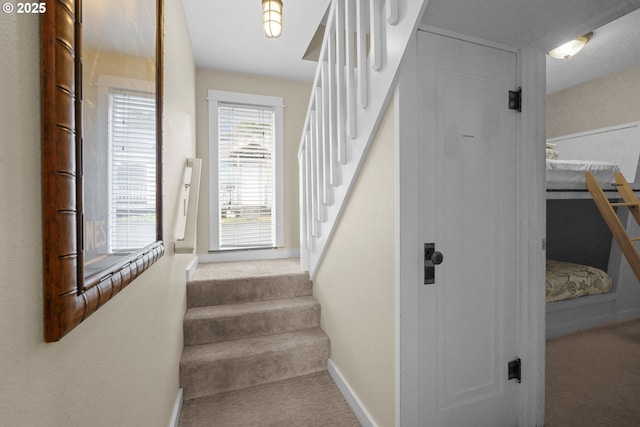 stairs featuring baseboards and carpet floors