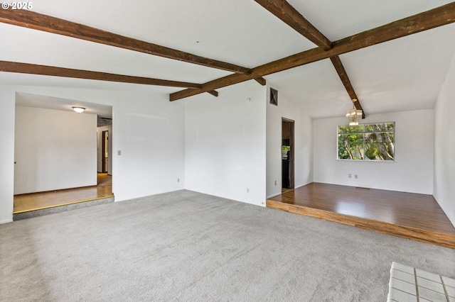 unfurnished living room with carpet floors and beam ceiling