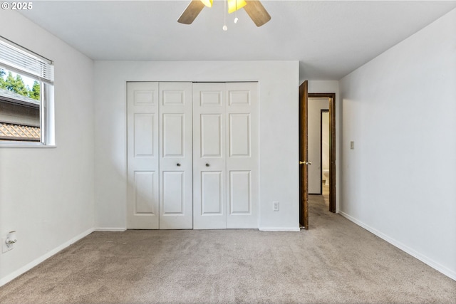 unfurnished bedroom with carpet floors, baseboards, ceiling fan, and a closet