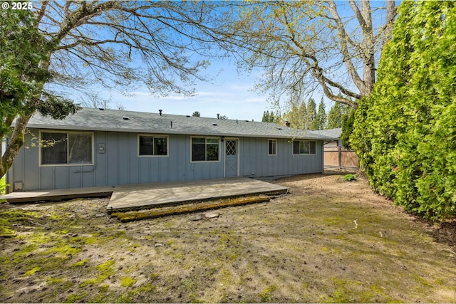 back of property featuring fence, a wooden deck, and board and batten siding