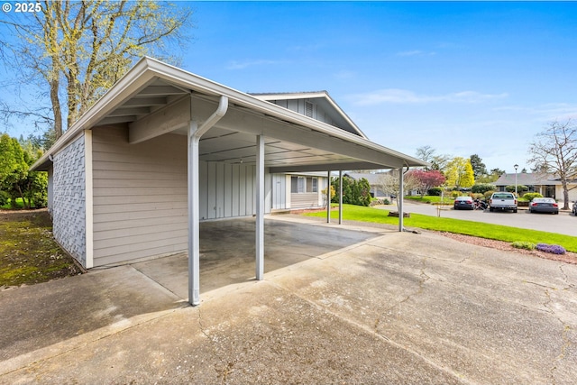 view of parking / parking lot featuring a carport and concrete driveway