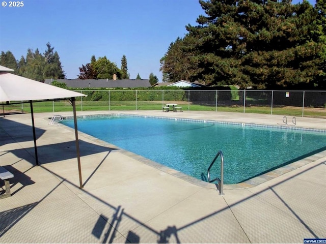 view of swimming pool with a fenced in pool, fence, and a patio
