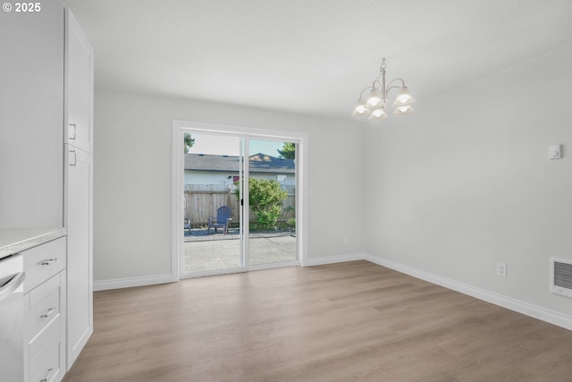 unfurnished dining area with a chandelier, baseboards, and light wood-style flooring