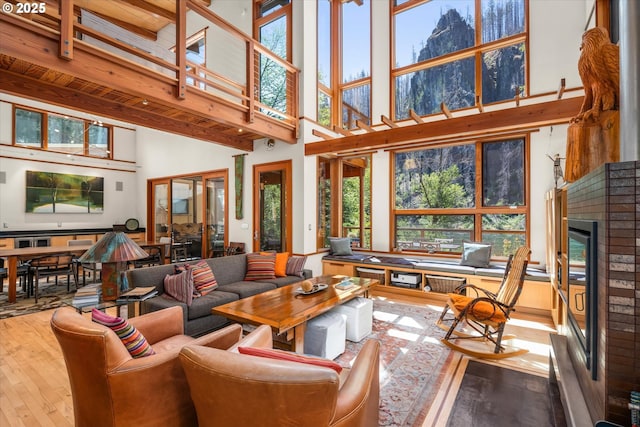 49348 Mckenzie Hwy, Vida, OR 97488 - living area featuring a towering ceiling, hardwood / wood-style floors, plenty of natural light, a fireplace, and beamed ceiling
