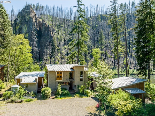 49348 Mckenzie Hwy, Vida, OR 97488 - view of front of property with a standing seam roof, metal roof, a porch, gravel driveway, and a wooded view