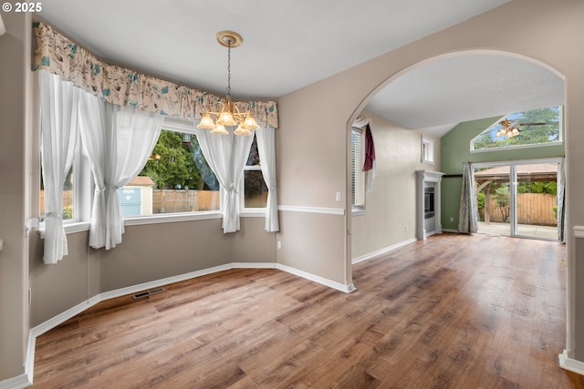 1670 NE Jackson School Rd, Hillsboro, OR 97124 - unfurnished dining area with a chandelier, wood finished floors, arched walkways, a ceiling fan, and healthy amount of natural light
