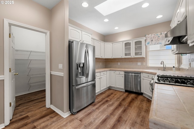 1670 NE Jackson School Rd, Hillsboro, OR 97124 - kitchen with appliances with stainless steel finishes, under cabinet range hood, a skylight, tile countertops, and a sink