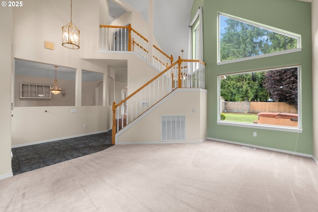1670 NE Jackson School Rd, Hillsboro, OR 97124 - unfurnished living room with a towering ceiling, carpet floors, a chandelier, stairway, and baseboards