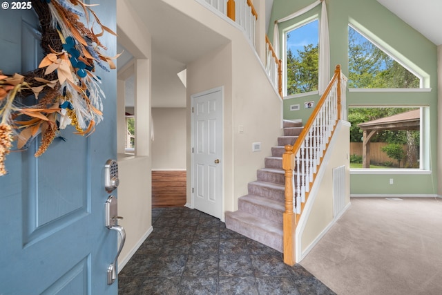 1670 NE Jackson School Rd, Hillsboro, OR 97124 - foyer entrance featuring healthy amount of natural light, stairs, baseboards, and dark stone finish flooring