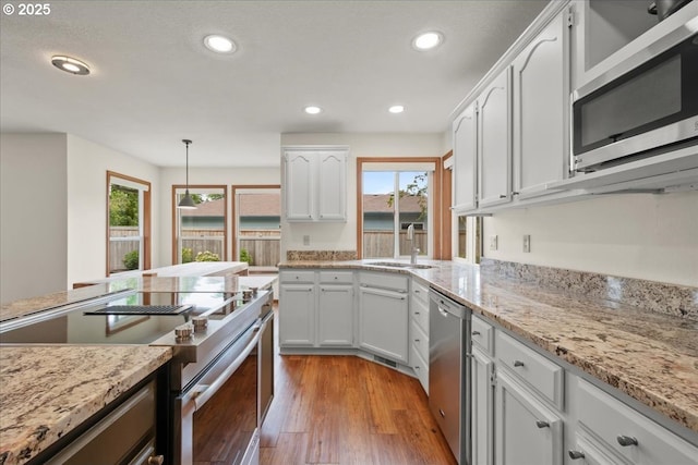 817 NW 141st St, Vancouver, WA 98685 - kitchen featuring appliances with stainless steel finishes, healthy amount of natural light, white cabinets, recessed lighting, and light wood finished floors