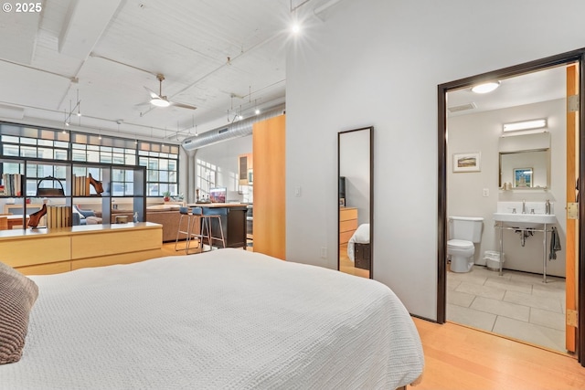 bedroom with ceiling fan, hardwood / wood-style floors, and ensuite bathroom