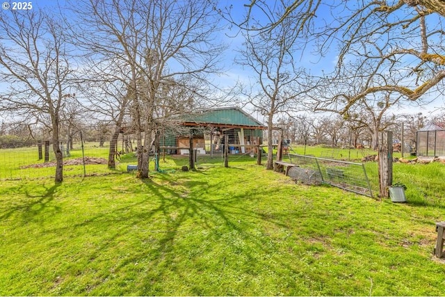 view of yard with fence and an outdoor structure