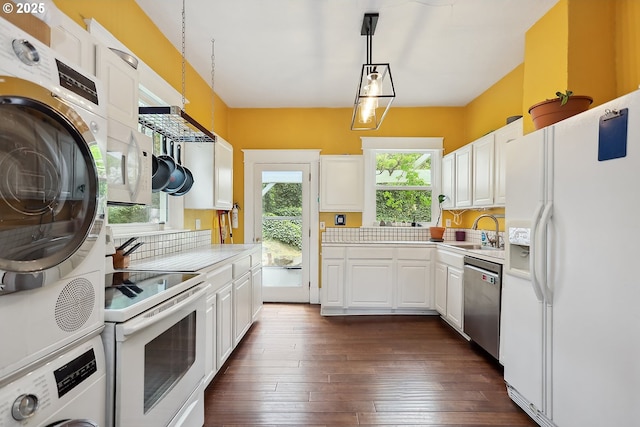 1006 4th Ave, Mosier, OR 97040 - kitchen featuring white appliances, estacked washer and dryer, light countertops, a sink, and white cabinets